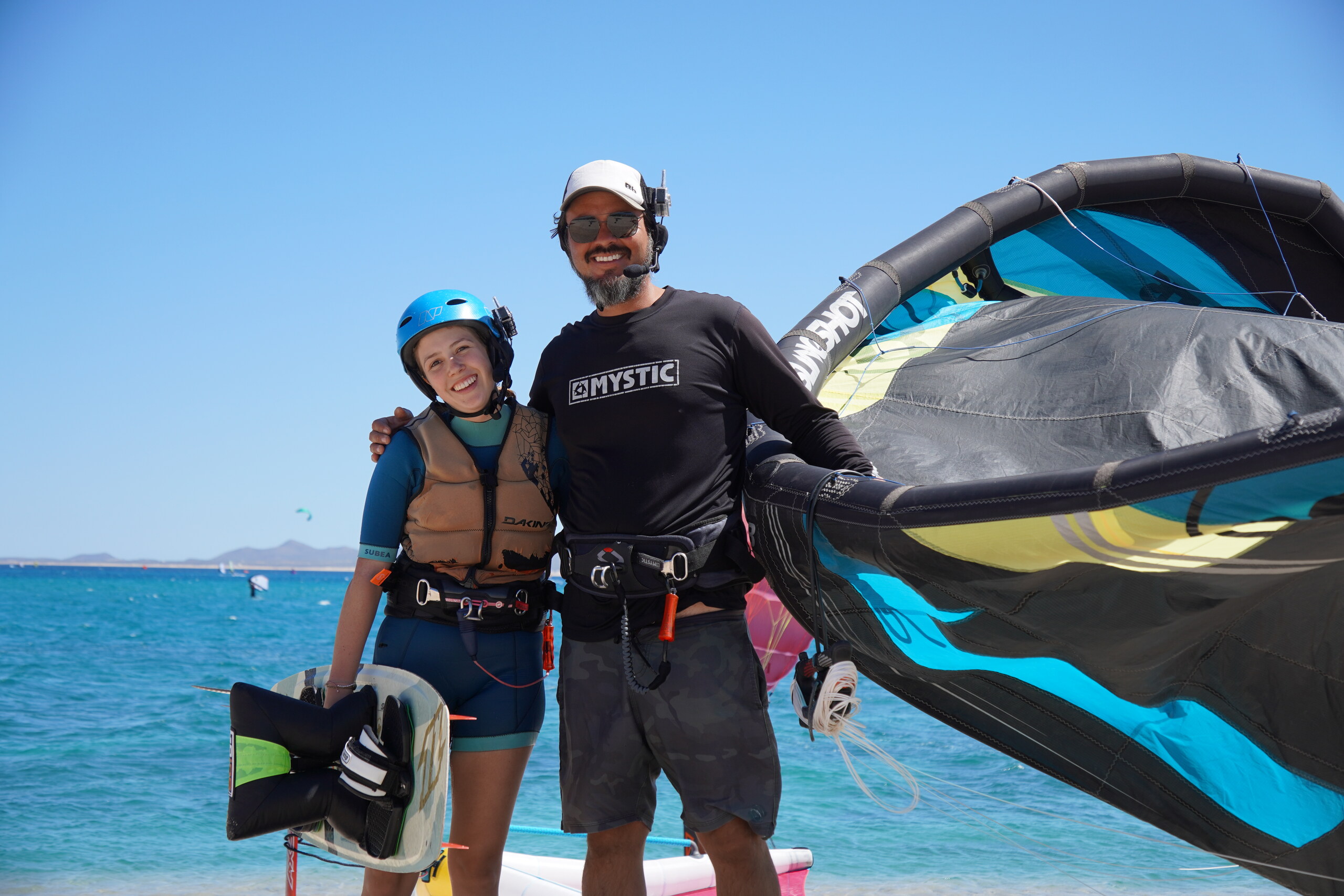 Kiteboarding student and instructor enjoying a sunny day at the beach